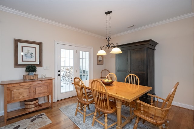 dining room with visible vents, crown molding, light wood-type flooring, and baseboards