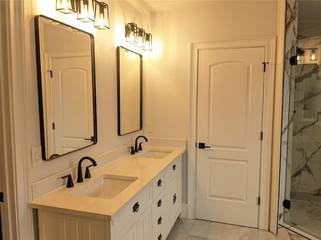 full bath with a sink, a marble finish shower, marble finish floor, and double vanity