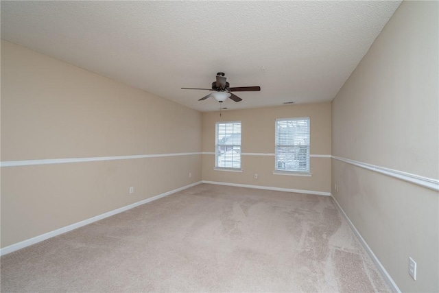 unfurnished room featuring light carpet, a textured ceiling, baseboards, and a ceiling fan