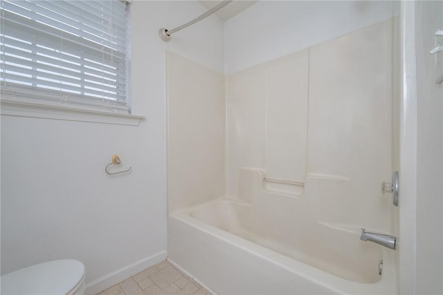 full bath with toilet, baseboards, and shower / bathtub combination