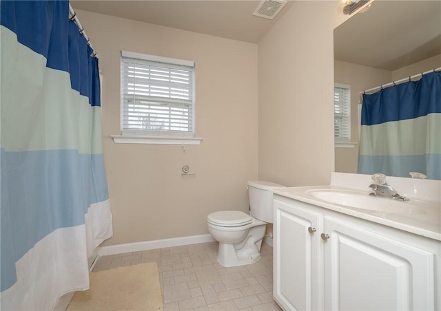 bathroom with visible vents, a healthy amount of sunlight, toilet, and vanity