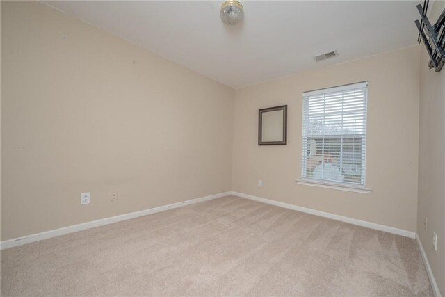 empty room with visible vents, light carpet, and baseboards