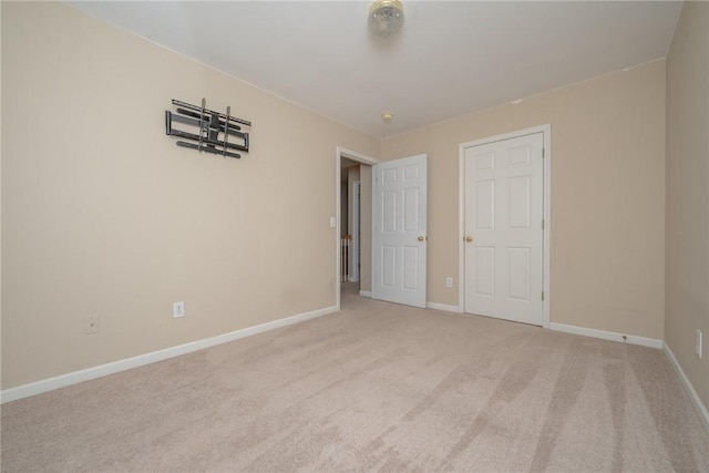 unfurnished bedroom with light carpet and baseboards