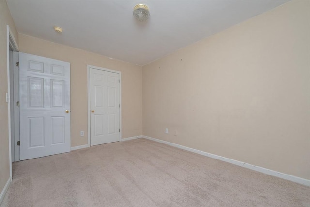 unfurnished bedroom with baseboards and light carpet