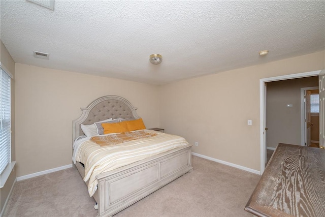 bedroom with light carpet, visible vents, and baseboards