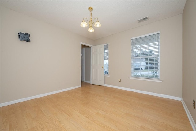 empty room featuring visible vents, baseboards, and light wood-style flooring