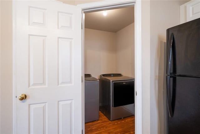 washroom featuring laundry area, independent washer and dryer, and dark wood-style flooring