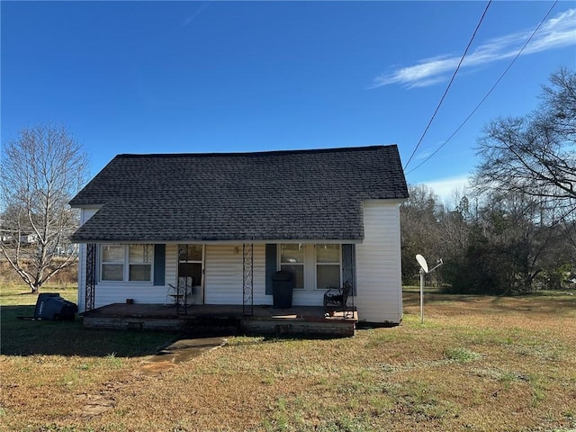 bungalow-style house featuring roof with shingles, covered porch, and a front lawn