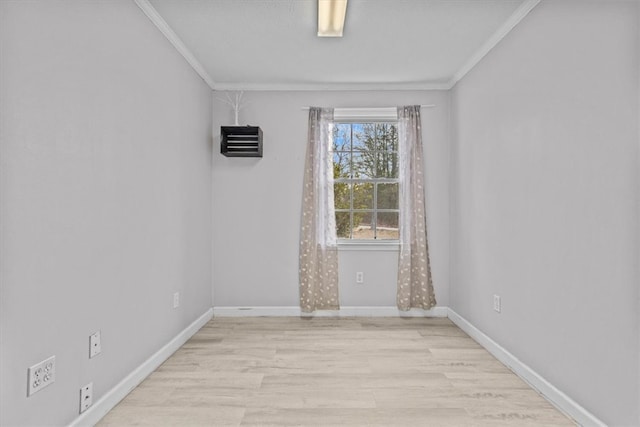 unfurnished room with crown molding, light wood-style flooring, and baseboards