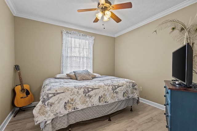 bedroom featuring baseboards, a ceiling fan, crown molding, and light wood finished floors