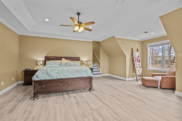 bedroom with recessed lighting, baseboards, a raised ceiling, and light wood finished floors