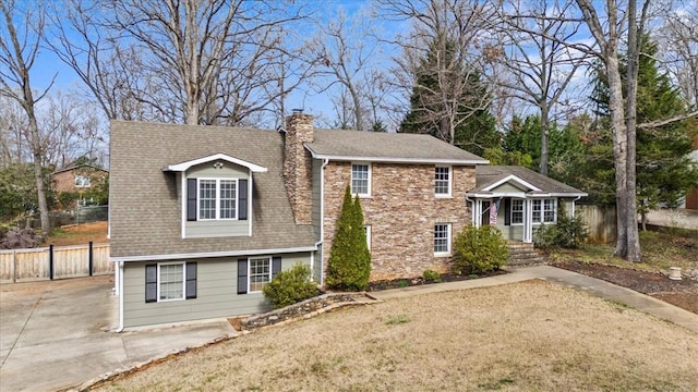 view of front of property with a shingled roof, concrete driveway, a chimney, and fence