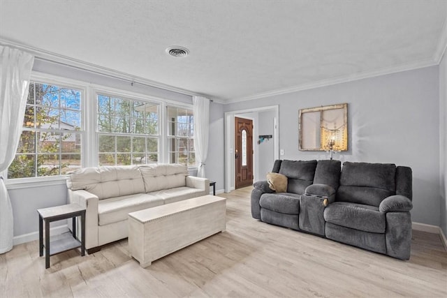 living room featuring visible vents, light wood-style floors, and ornamental molding