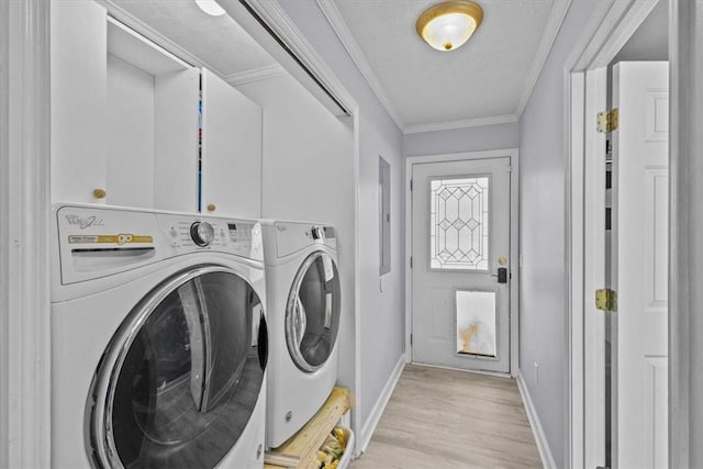 clothes washing area with washing machine and clothes dryer, crown molding, baseboards, laundry area, and light wood-style flooring