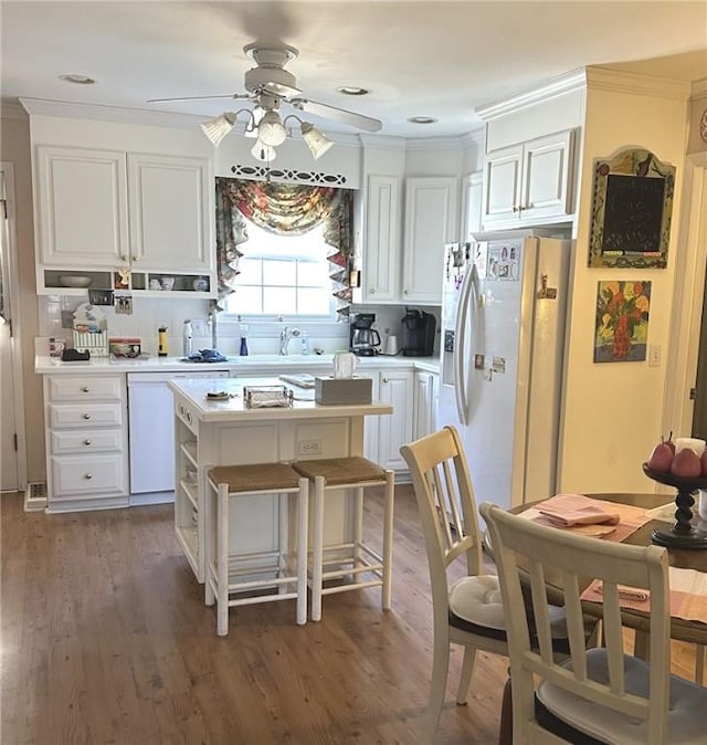 kitchen with white appliances, light wood-style flooring, light countertops, and crown molding