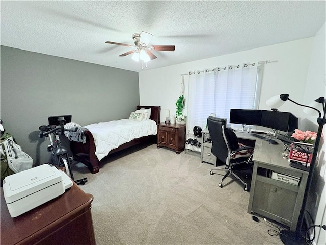 bedroom with a textured ceiling, ceiling fan, and light carpet