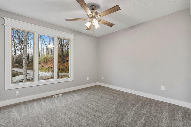 spare room featuring visible vents, carpet flooring, a textured ceiling, and baseboards