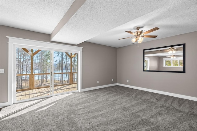 carpeted spare room featuring ceiling fan, a textured ceiling, and baseboards