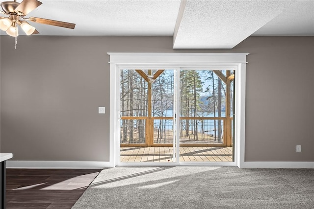 interior space with ceiling fan, baseboards, and a textured ceiling