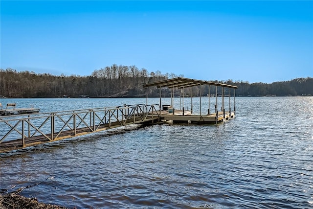 view of dock featuring a view of trees and a water view