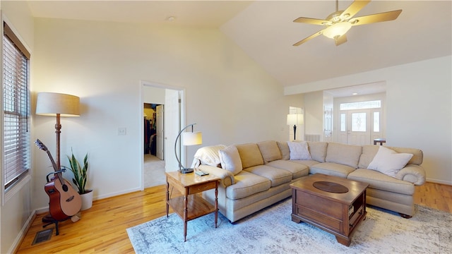 living room with visible vents, high vaulted ceiling, light wood-style floors, baseboards, and ceiling fan