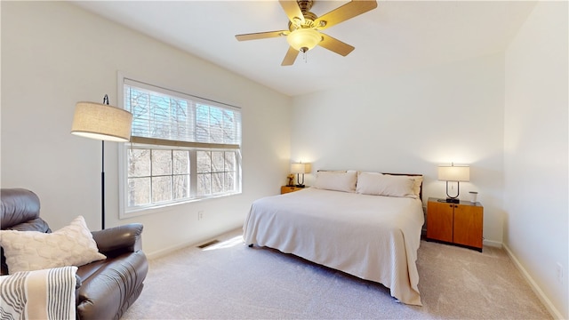 bedroom with ceiling fan, visible vents, baseboards, and light carpet