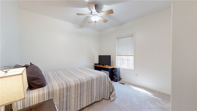 bedroom with visible vents, light colored carpet, and ceiling fan