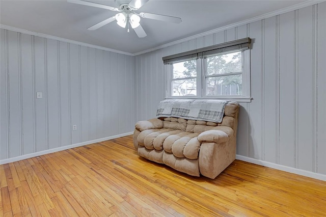 sitting room featuring light wood-type flooring, baseboards, and ornamental molding