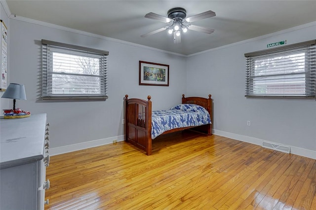 bedroom with visible vents, multiple windows, ornamental molding, and light wood finished floors