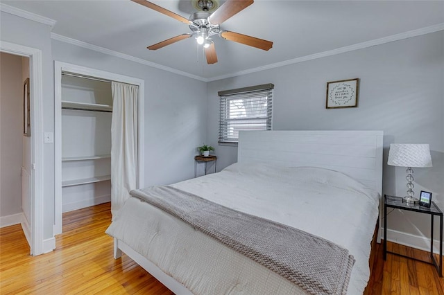 bedroom featuring baseboards, light wood-style flooring, ceiling fan, a closet, and crown molding