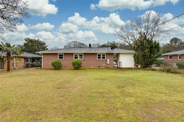 rear view of property with crawl space, a lawn, brick siding, and fence