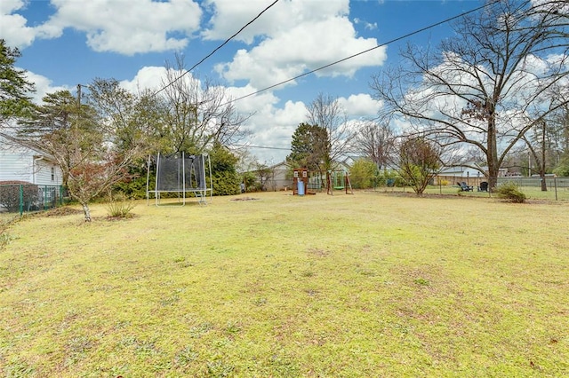 view of yard with a trampoline and a fenced backyard