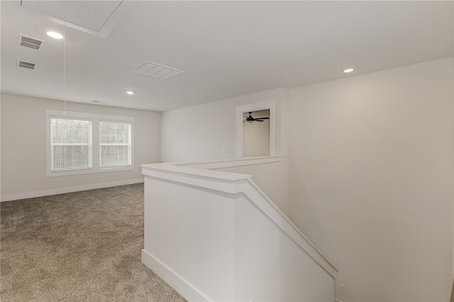 hall featuring carpet, attic access, an upstairs landing, and visible vents