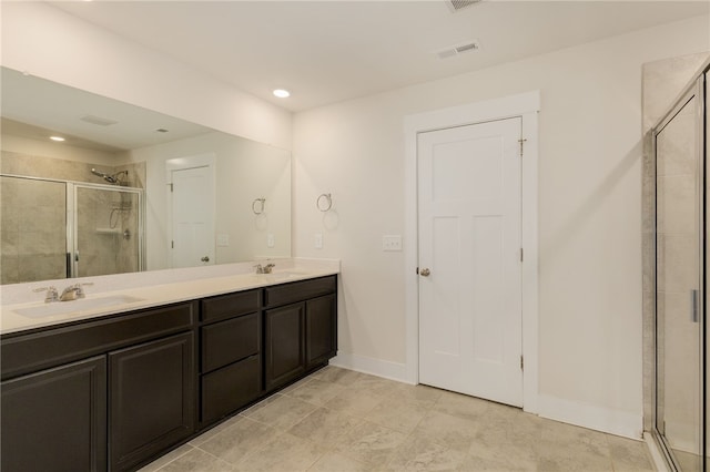 bathroom featuring visible vents, a shower stall, and a sink