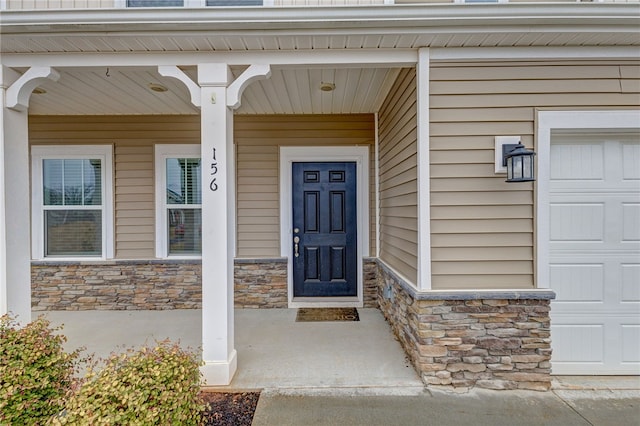 doorway to property with stone siding and a garage