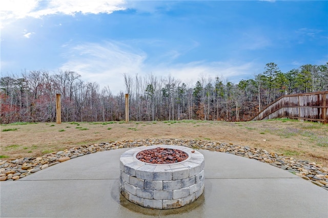 view of patio / terrace featuring a forest view and an outdoor fire pit