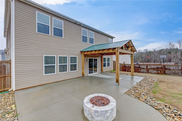 rear view of house with a gazebo, metal roof, a patio, and fence