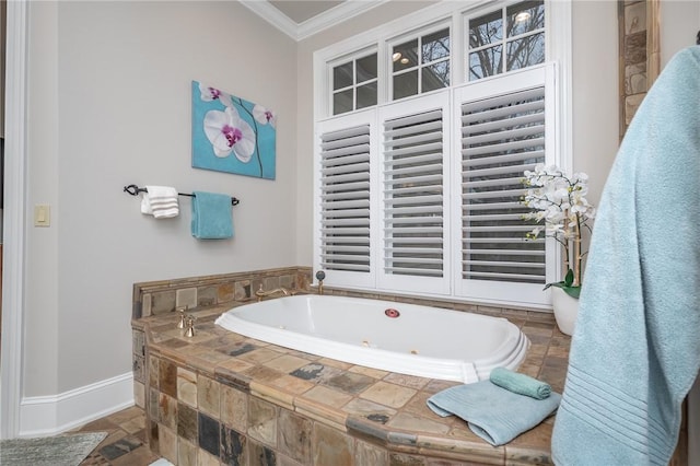 bathroom featuring baseboards, a whirlpool tub, crown molding, and stone finish floor