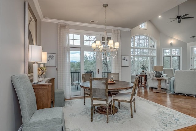 dining space with crown molding, plenty of natural light, wood finished floors, and visible vents