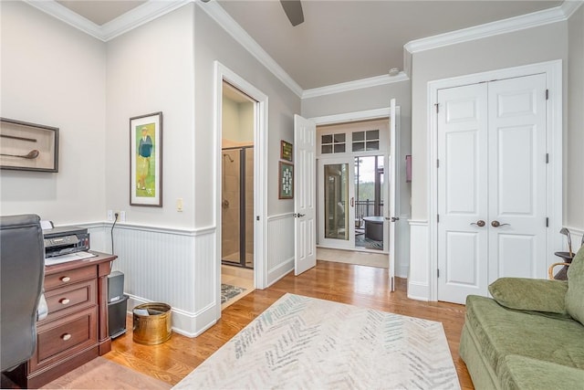 office space featuring crown molding, a wainscoted wall, and light wood finished floors