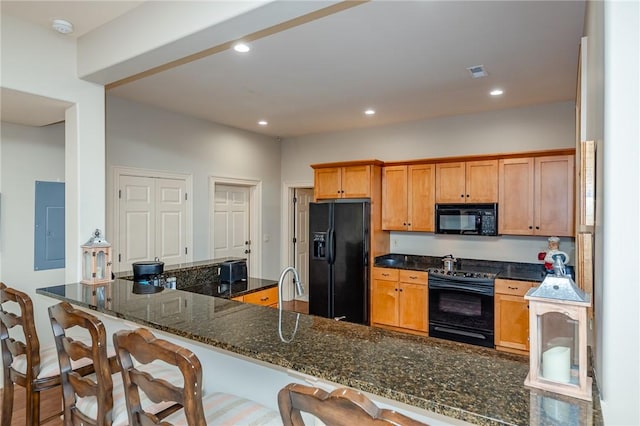 kitchen featuring black appliances, electric panel, recessed lighting, and dark stone counters