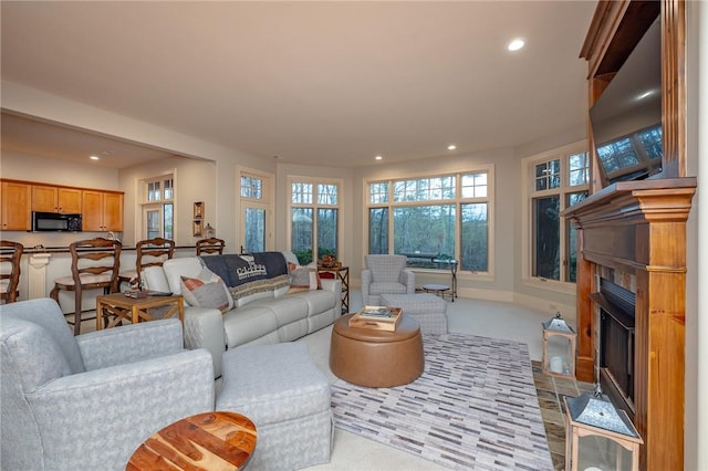 living area with a fireplace with flush hearth and recessed lighting