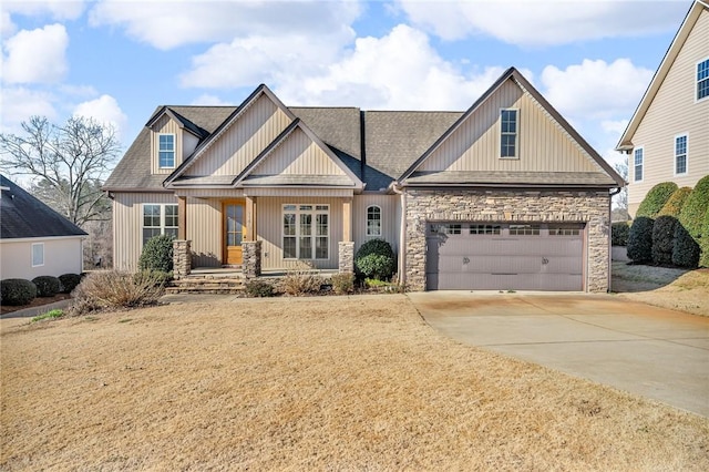 craftsman house with stone siding, driveway, and roof with shingles