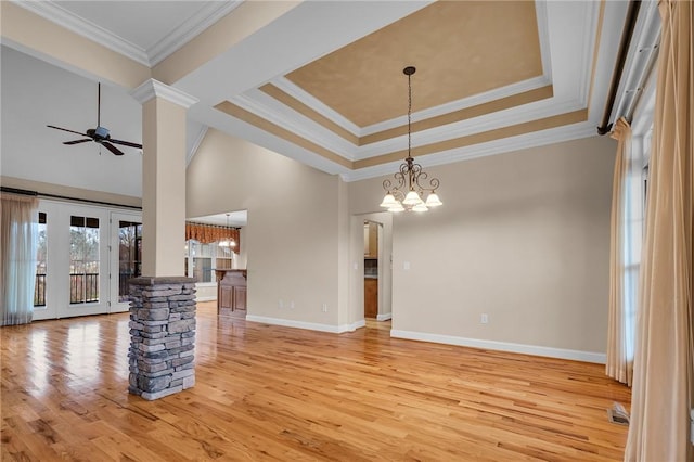 114 Royal Troon, Campobello, SC 29322 - unfurnished living room with ornate columns, light wood finished floors, a tray ceiling, ornamental molding, and ceiling fan with notable chandelier