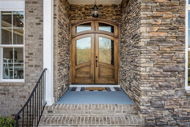 property entrance with stone siding and french doors