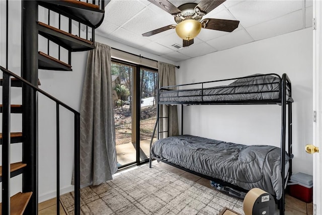 bedroom with a paneled ceiling, visible vents, and ceiling fan