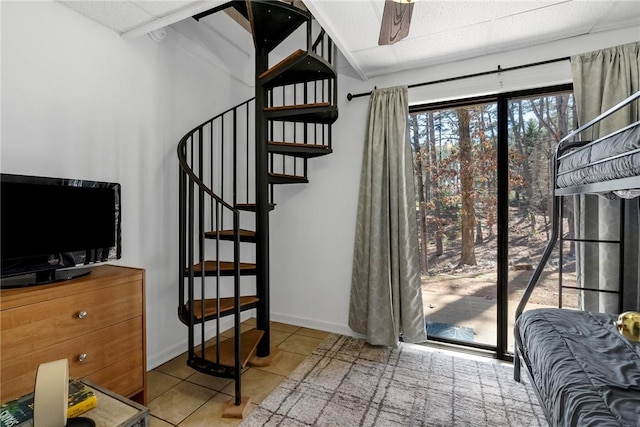 interior space featuring tile patterned floors, stairway, baseboards, and ceiling fan