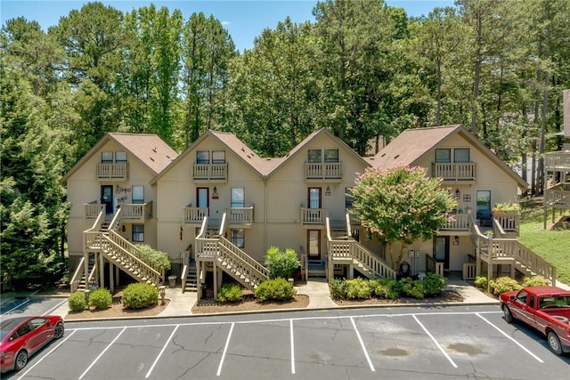 view of property featuring stairs and uncovered parking