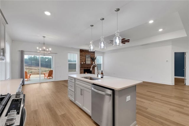 kitchen with a sink, stainless steel appliances, a large fireplace, and open floor plan