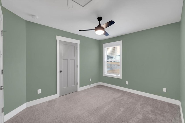 carpeted spare room with baseboards and ceiling fan